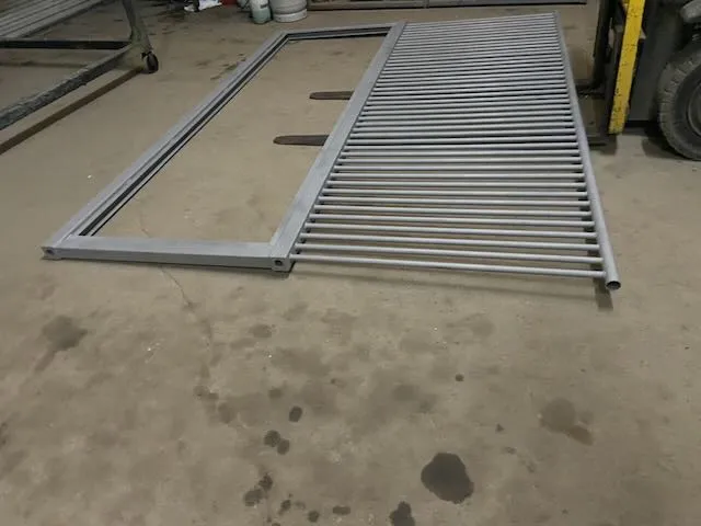 Finished gray powder coated gate panel with mesh infill indoors