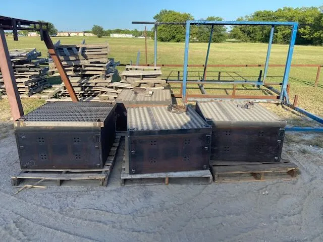 Three dark steel livestock panels on pallets showing heavy rust